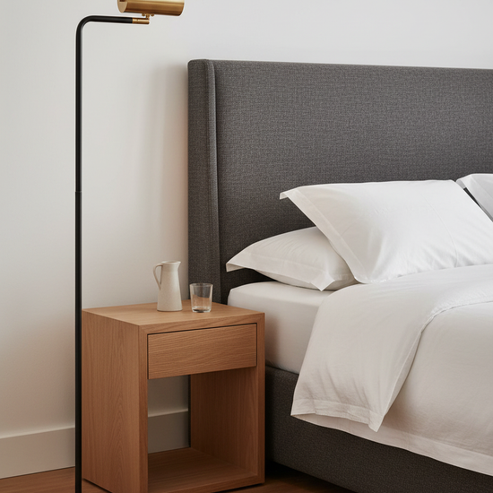 Candeeiro de pé preto em quarto contemporâneo sofisticado com cabeceira em linho carvão e roupa de cama branca